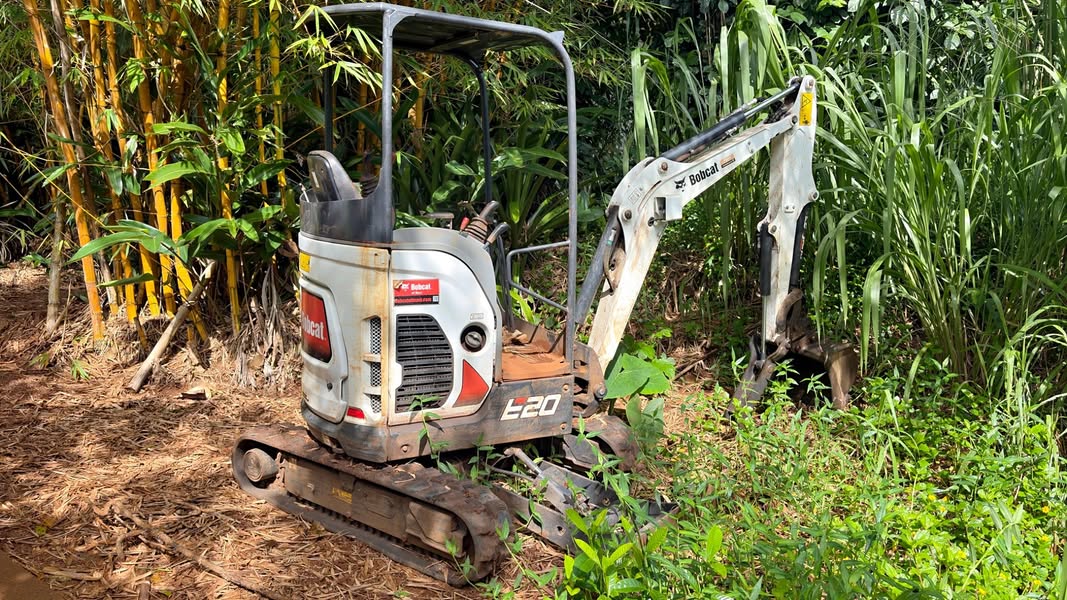 Actual Bobcat E20 mini excavator with rubber tracks, wider toothed bucket, and hydraulic clamp thumb